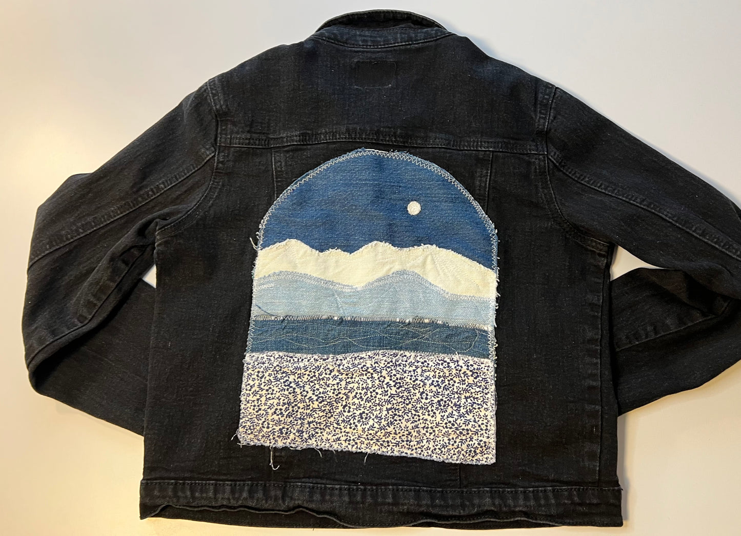 Black denim jacket with blue denim patch