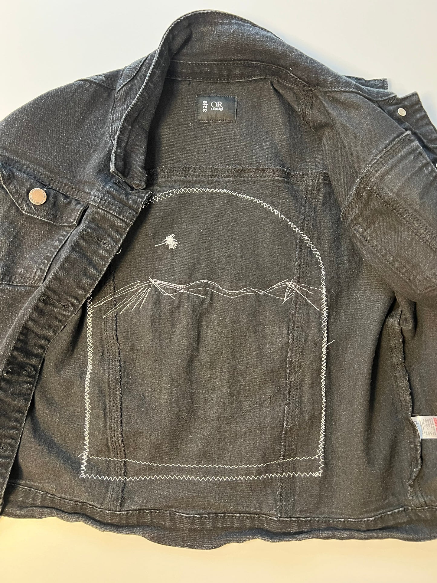 Black denim jacket with blue denim patch